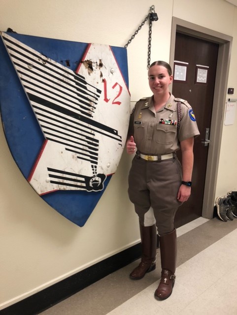 Cadet Emily Shireman poses in front of Squadron 12 sign