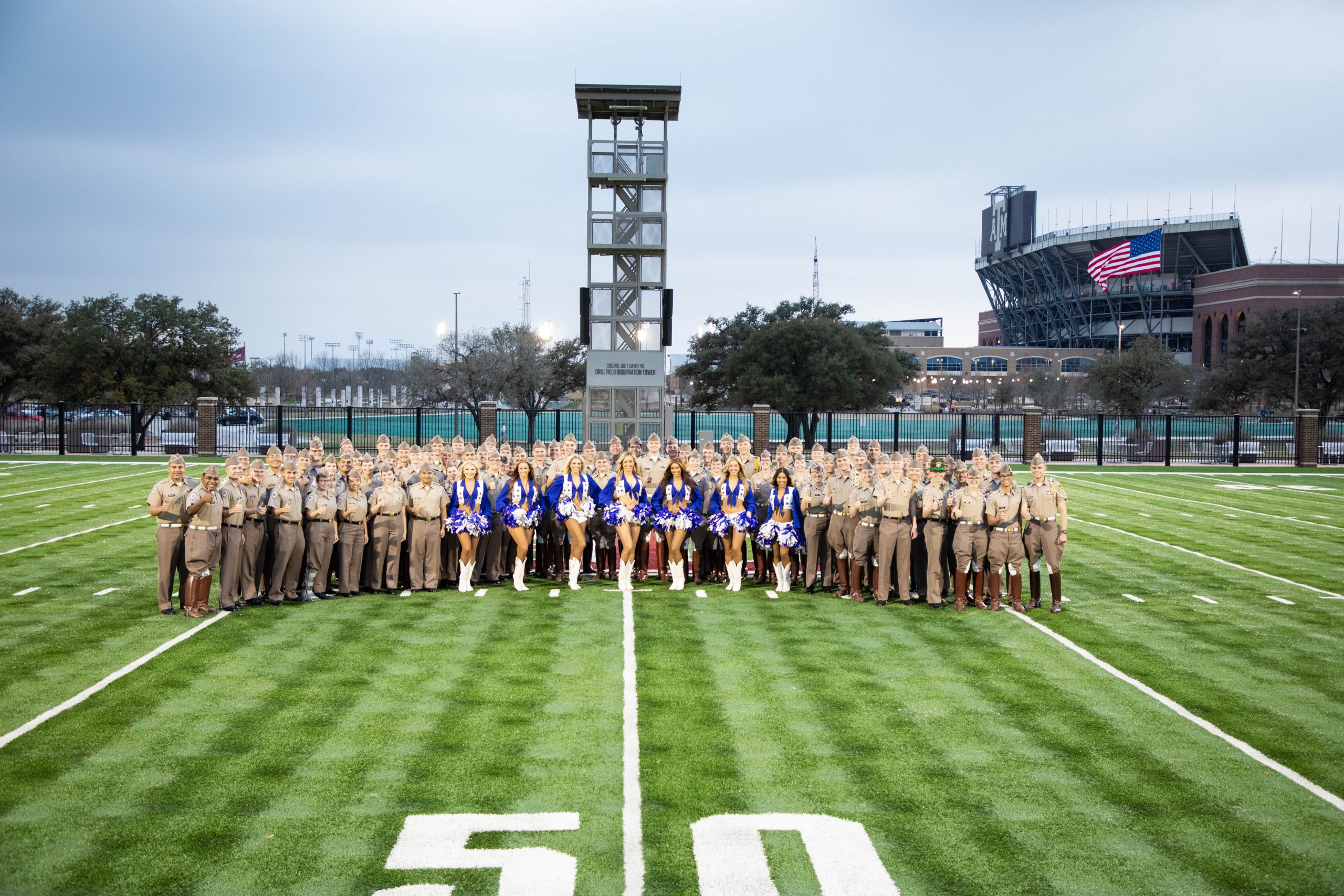 Cadets and Dallas Cowboy Cheerleaders pose on Dunlap Drill Field