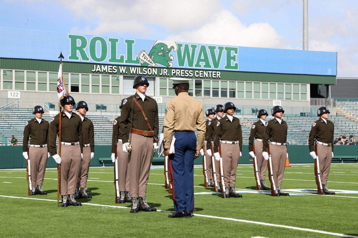 Fish Drill Team stands on Tulane's football field while being graded by a Marine.