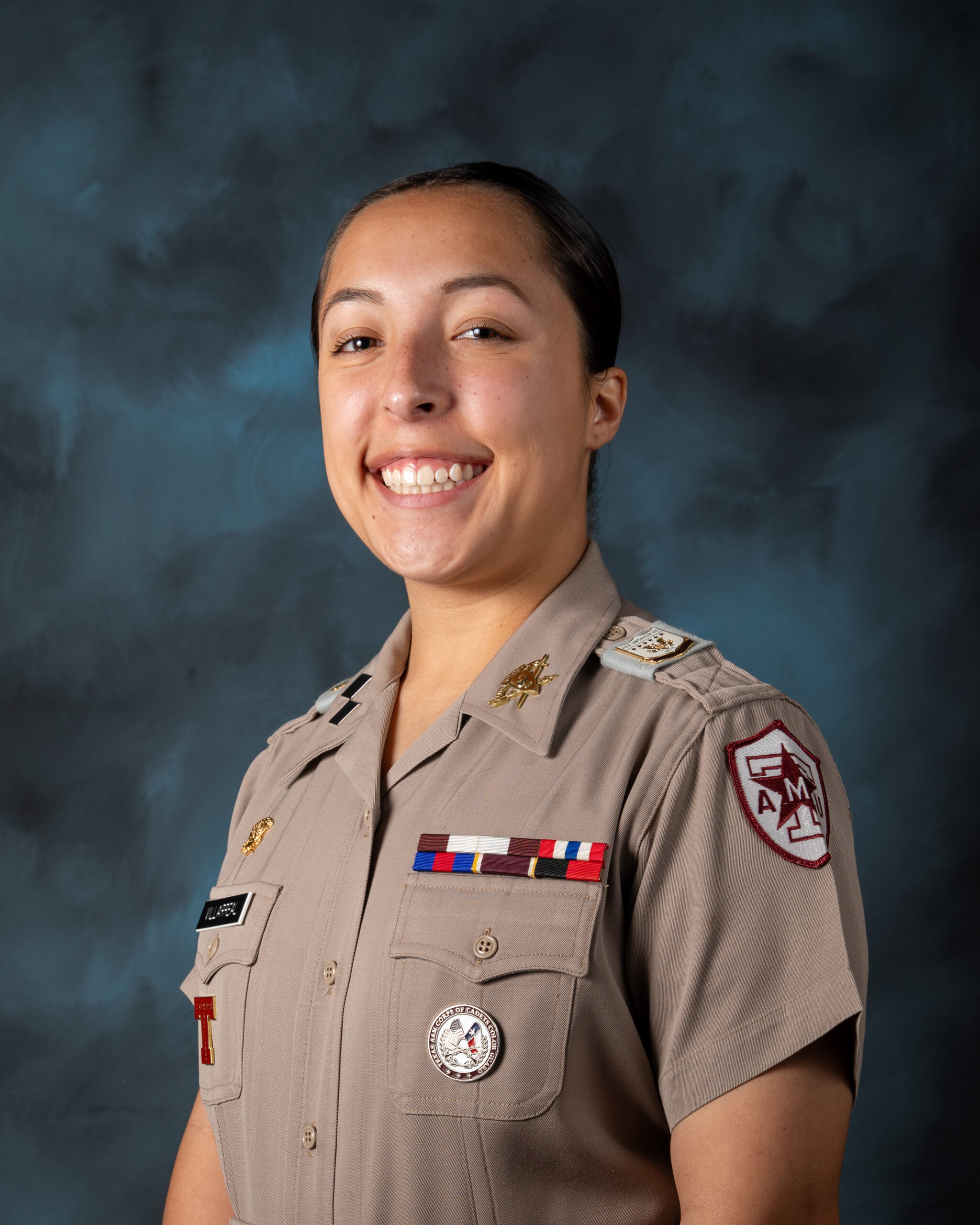 Aurora Villarreal '25 poses in front of a blue studio background.