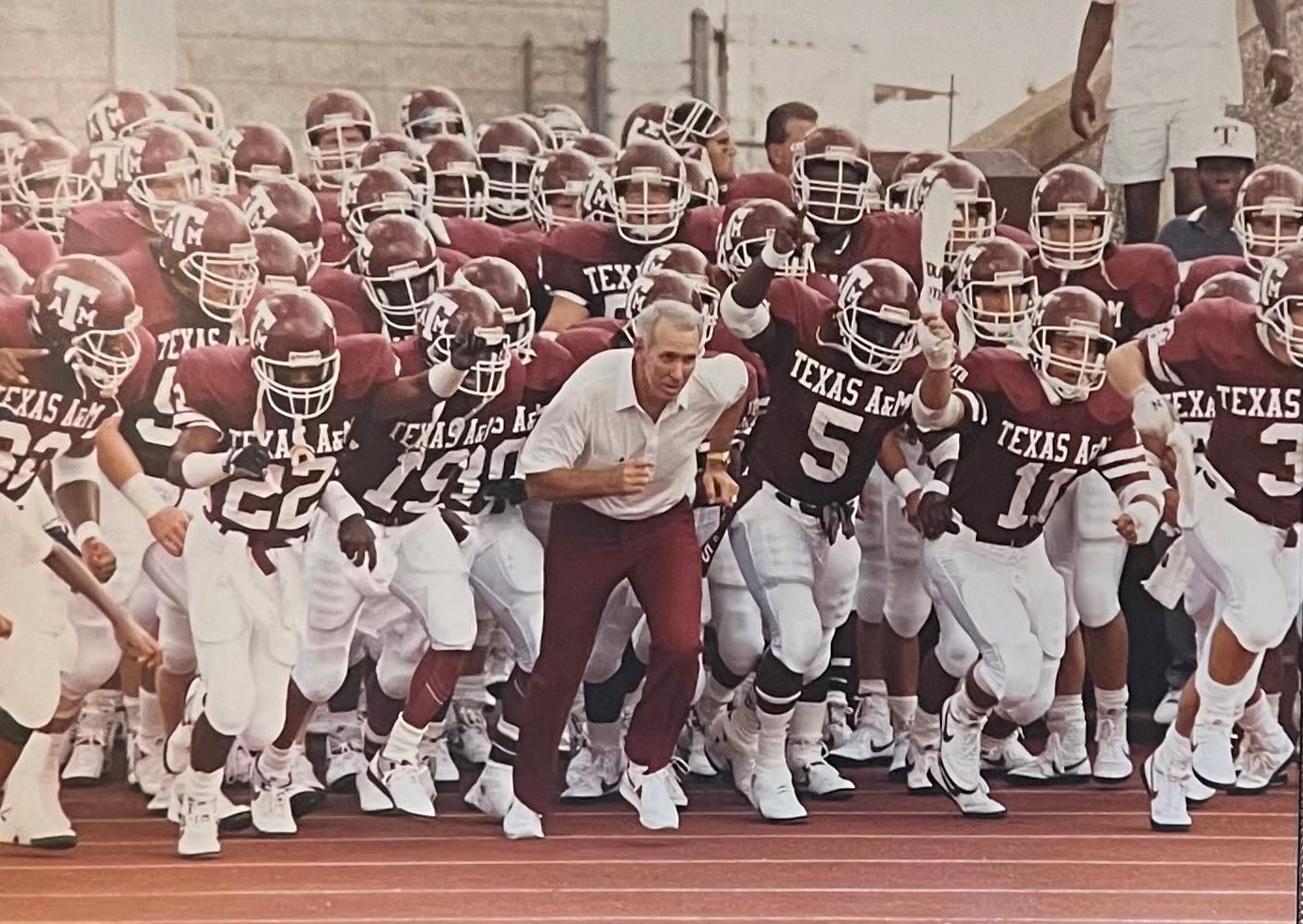 McPike, #11, runs out alongside R.C. Slocum ahead of an Aggie football game. 