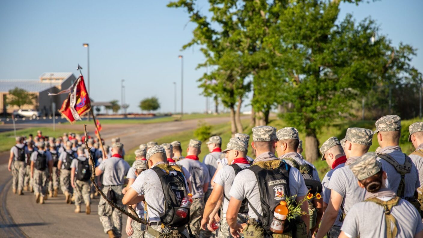 The back of heads of people walking on a street.