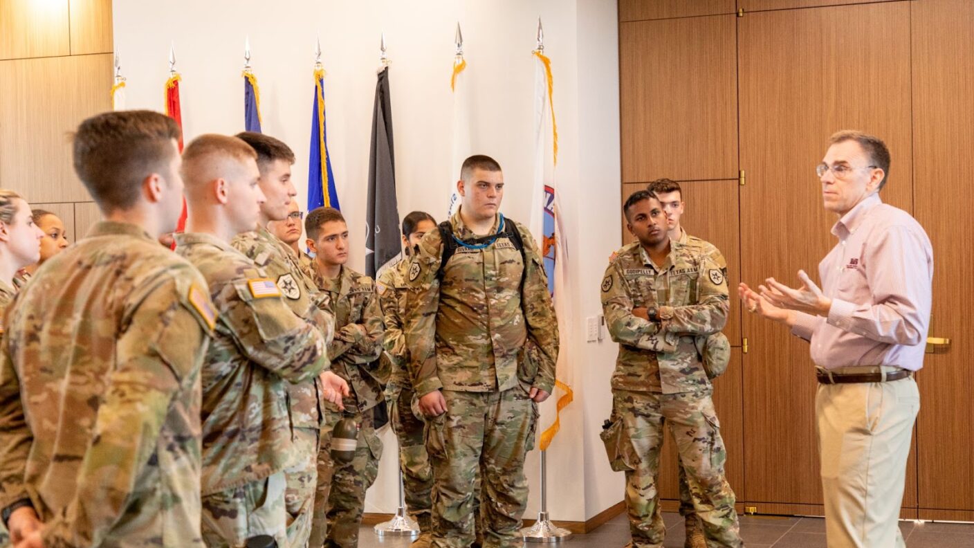 A man teaching a group of cadets.