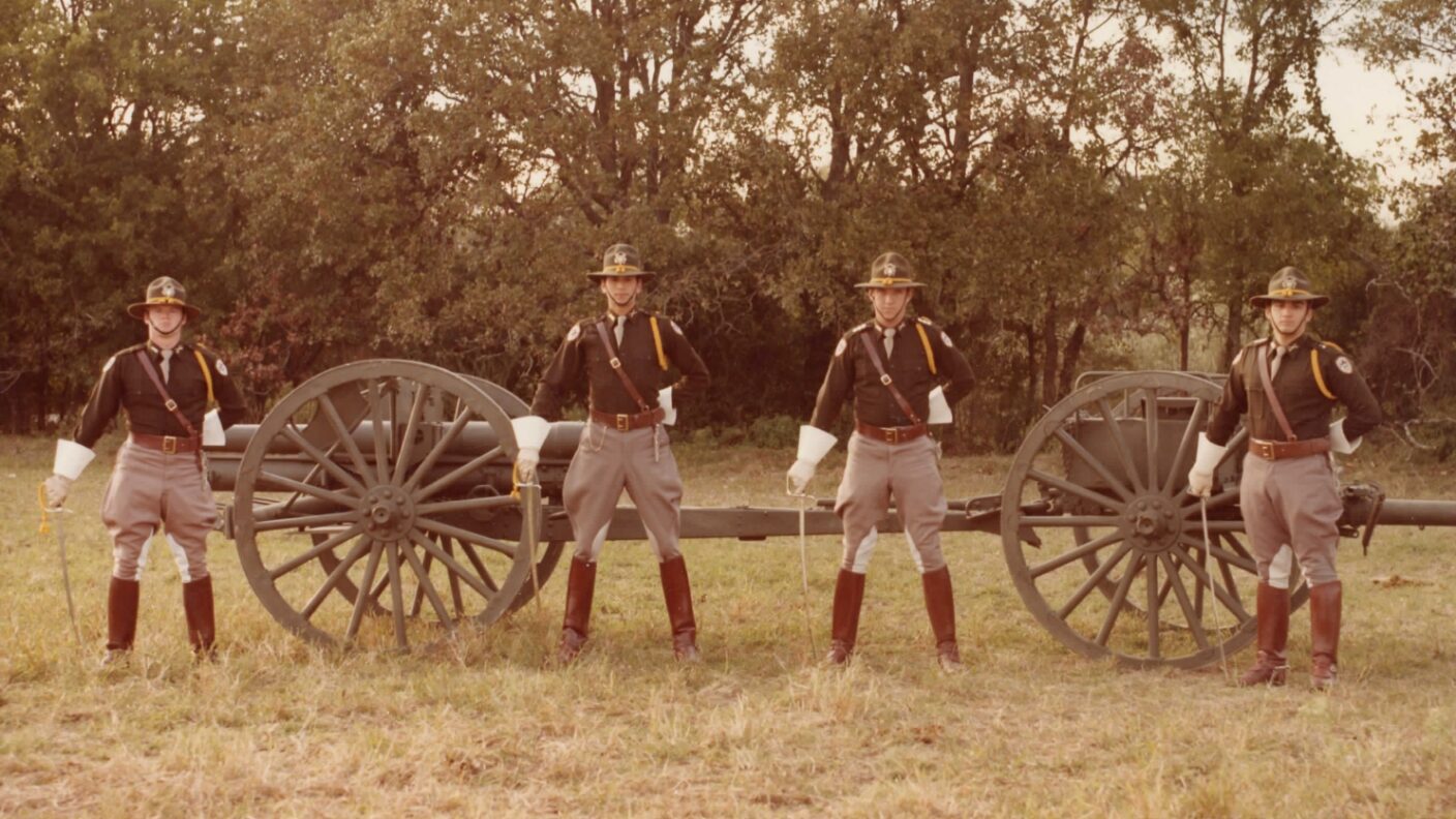 Old photo of cadets standing in front of cannon.