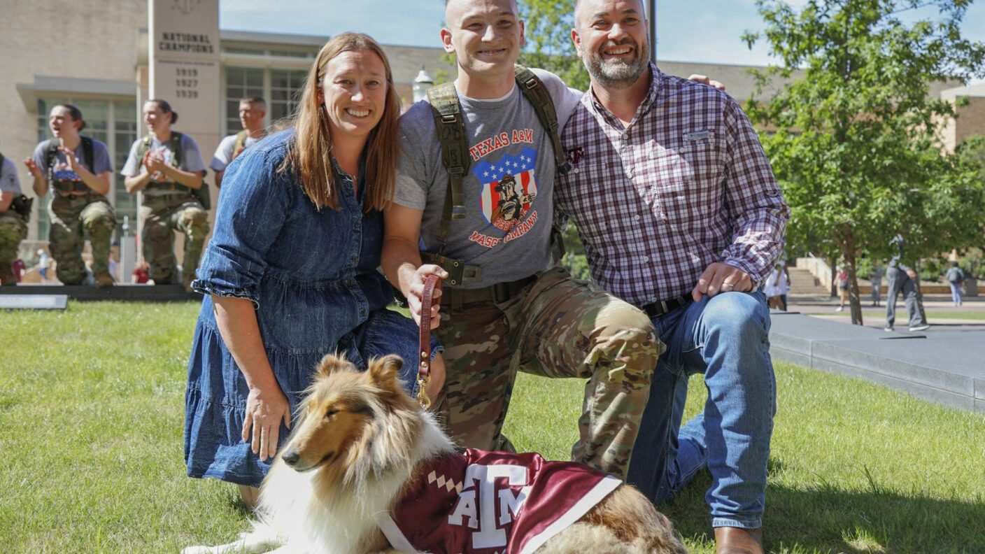 A mother and father posing with their son and the Texas A&M mascot.