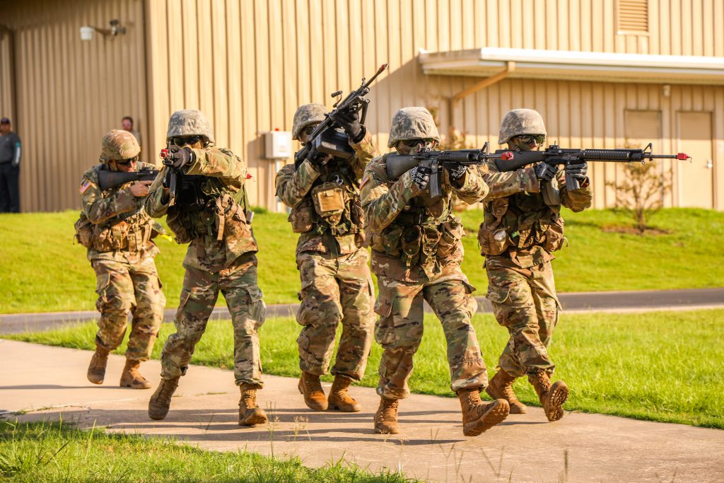 Men running in camo with guns.