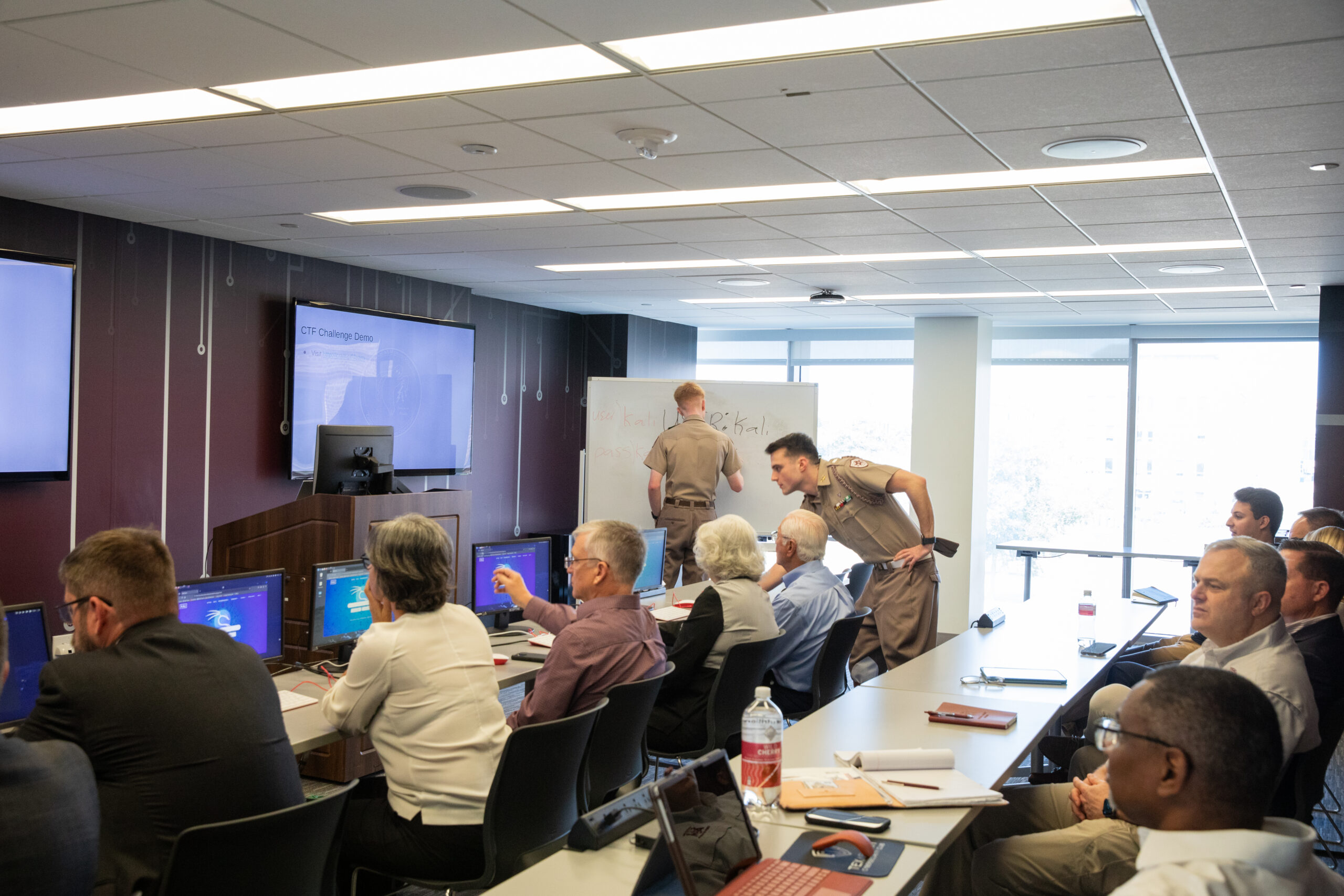 A group of people in a room sitting in front of computers.