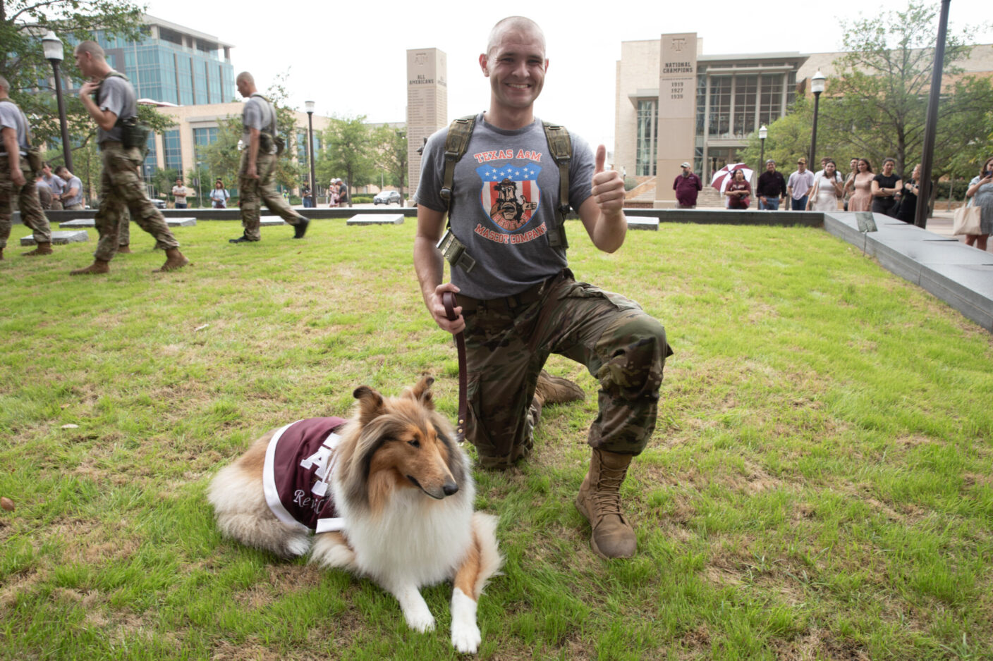 A boy and a rough collie pose on grass.