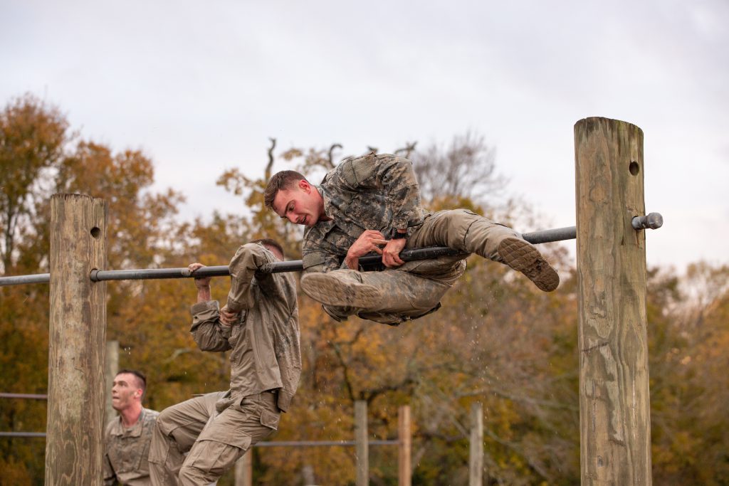 A guy flipping over a pole.