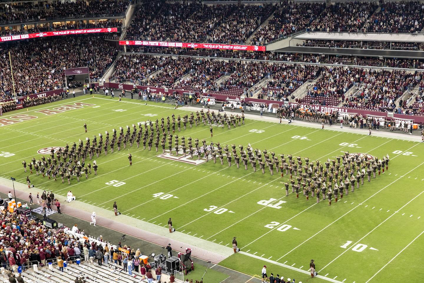 Band members creating a T on the football field.
