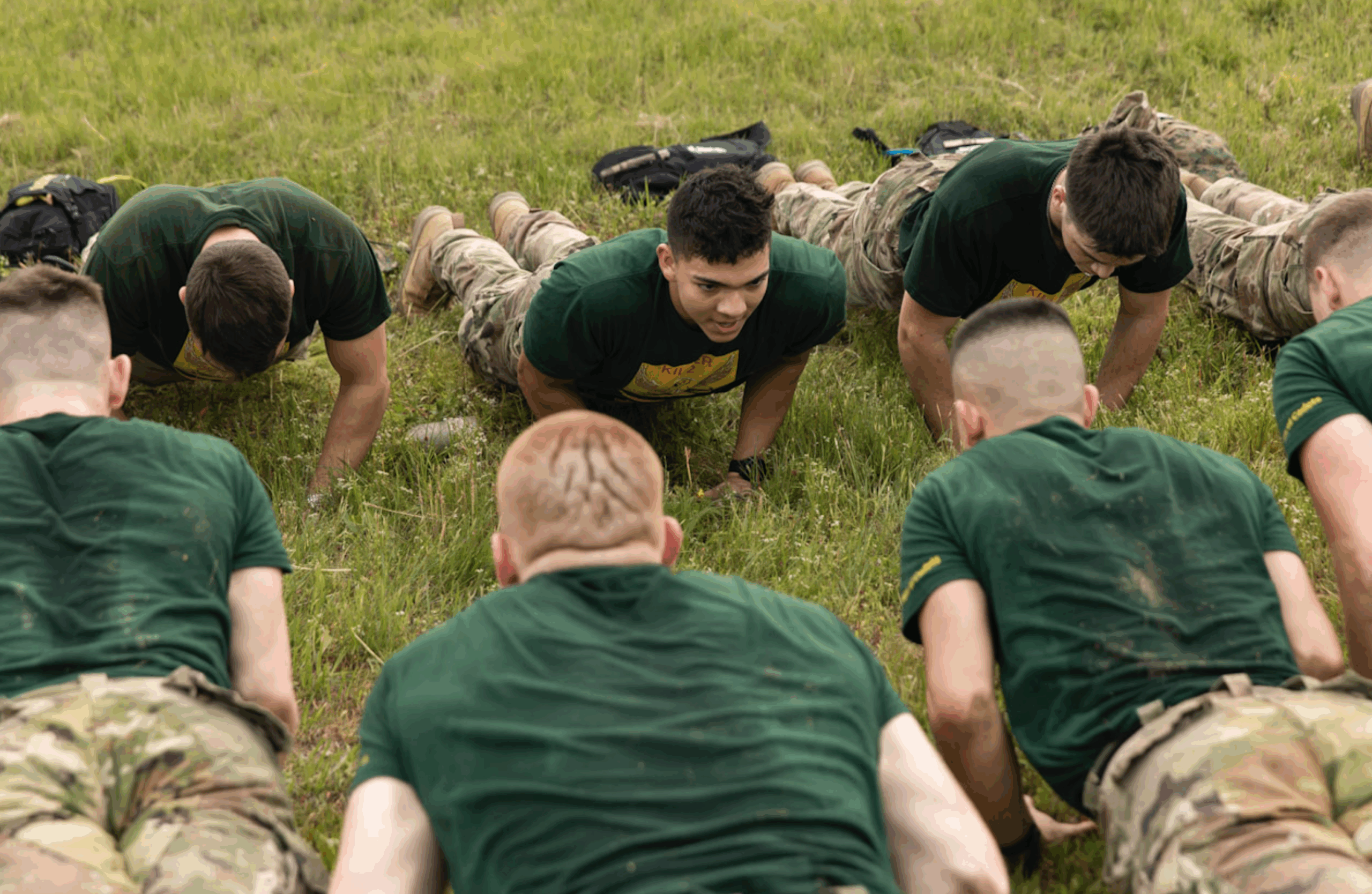 Cadets in the same uniform doing push ups.